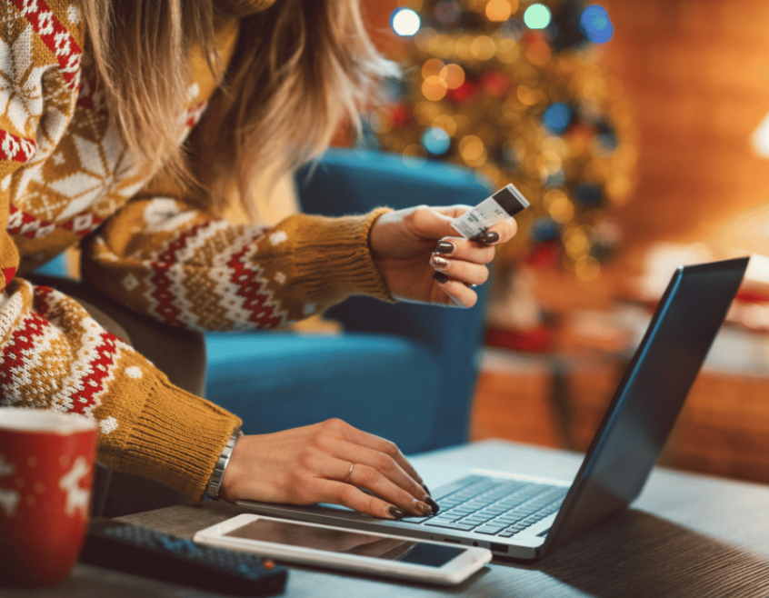 Image of online shopper with holiday decorations in background